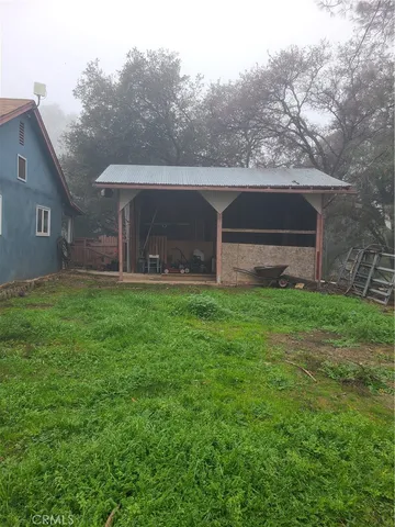 a front view of house with yard and trees in the background