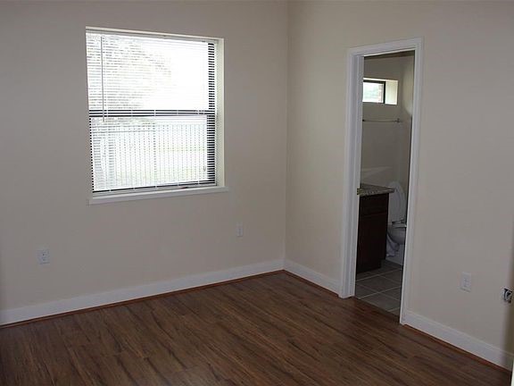 10102 Neuens Road, Unit A302 Houston, TX 77080 - Photo 3 of 8 an empty room with wooden floor and windows