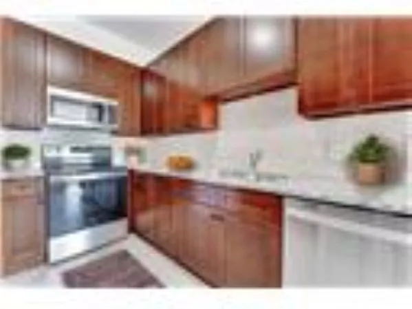 a kitchen with stainless steel appliances wooden cabinets a sink and a refrigerator