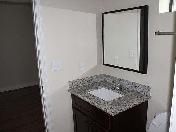 10102 Neuens Road, Unit A302 Houston, TX 77080 - Photo 4 of 8 a bathroom with a granite countertop sink and a mirror
