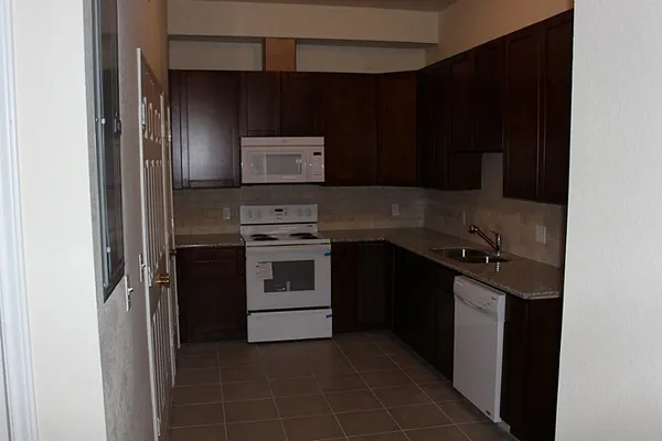 a bathroom with a granite countertop bathtub shower sink and toilet