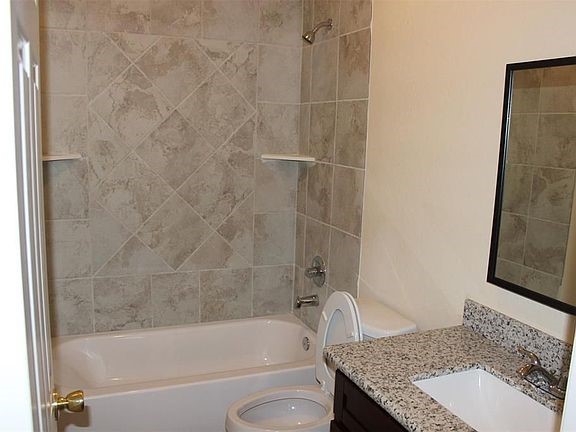 10102 Neuens Road, Unit A302 Houston, TX 77080 - Photo 7 of 8 a bathroom with a granite countertop bathtub shower sink and toilet