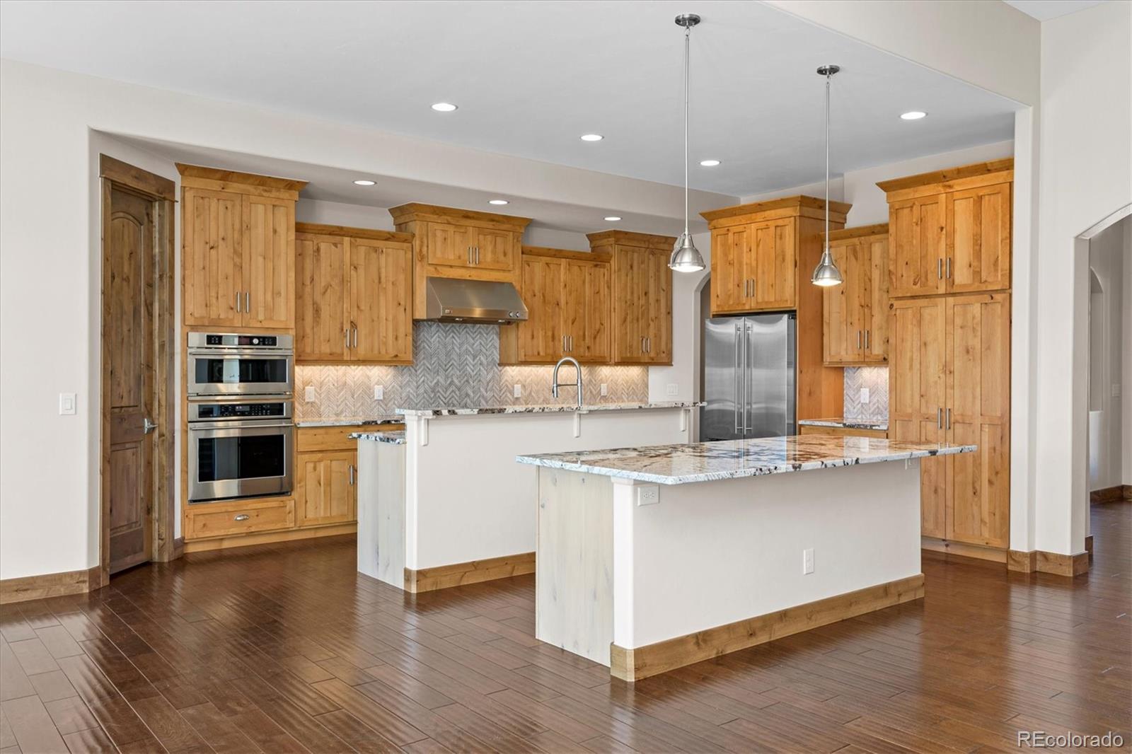 5561 Rim View Place Parker, CO 80134 - Photo 11 of 40 a kitchen with stainless steel appliances granite countertop a stove and a refrigerator
