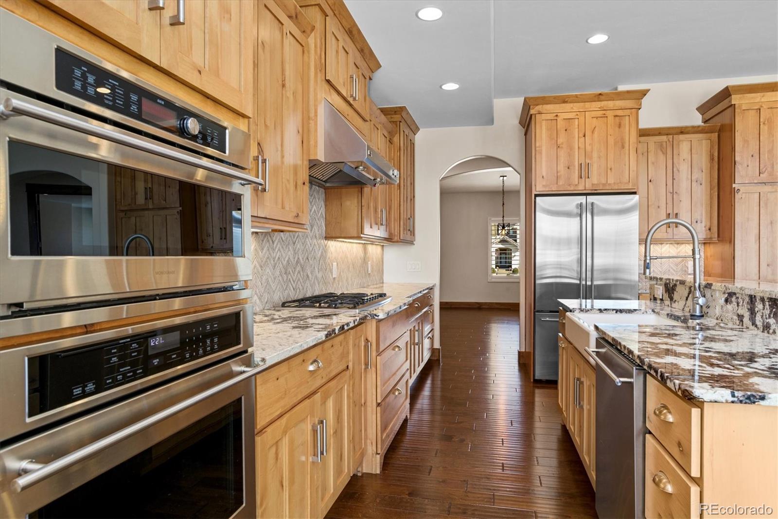 5561 Rim View Place Parker, CO 80134 - Photo 13 of 40 a kitchen with stainless steel appliances granite countertop a stove and a refrigerator