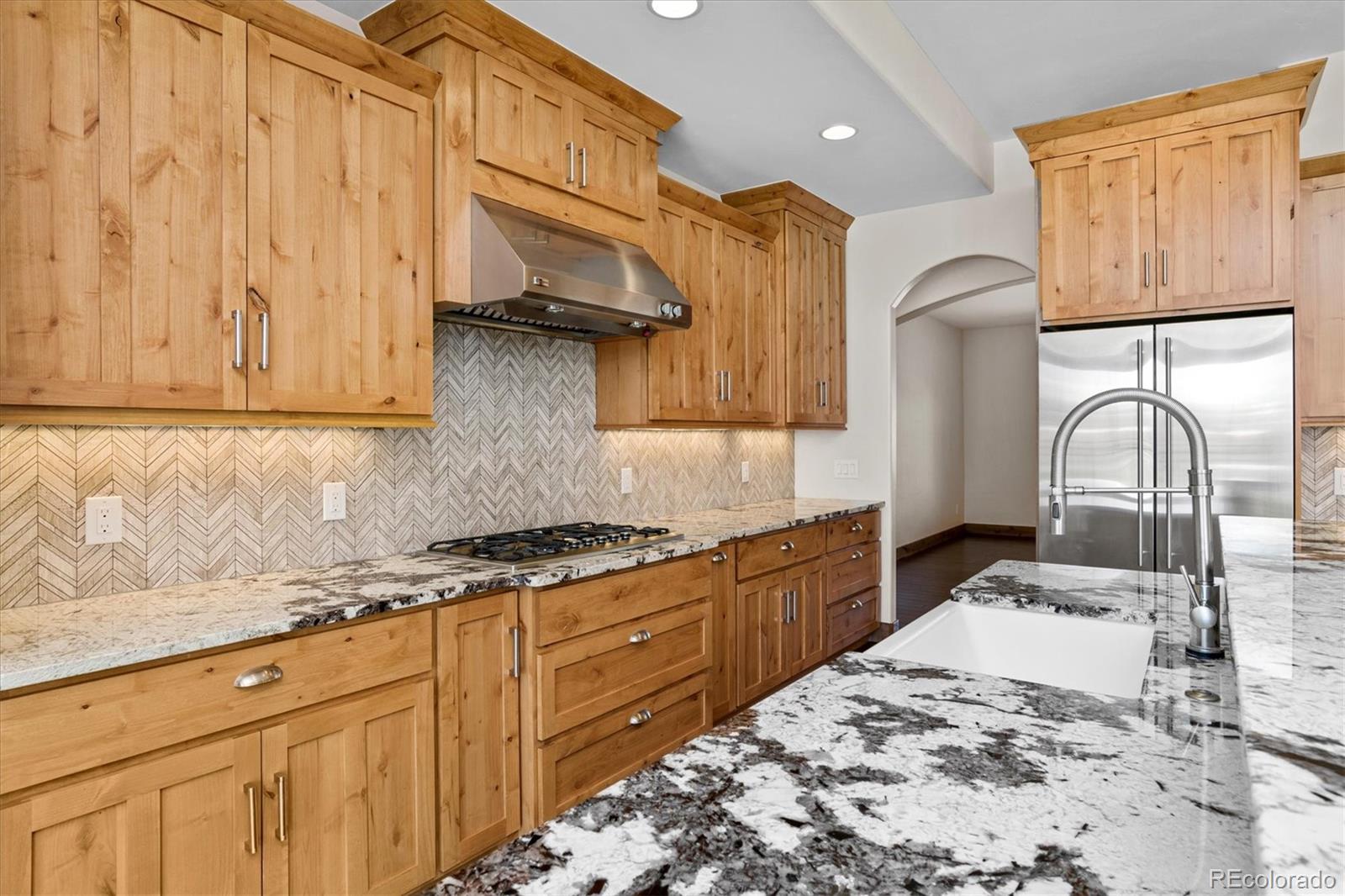 5561 Rim View Place Parker, CO 80134 - Photo 14 of 40 a kitchen with stainless steel appliances granite countertop a stove a sink and a microwave