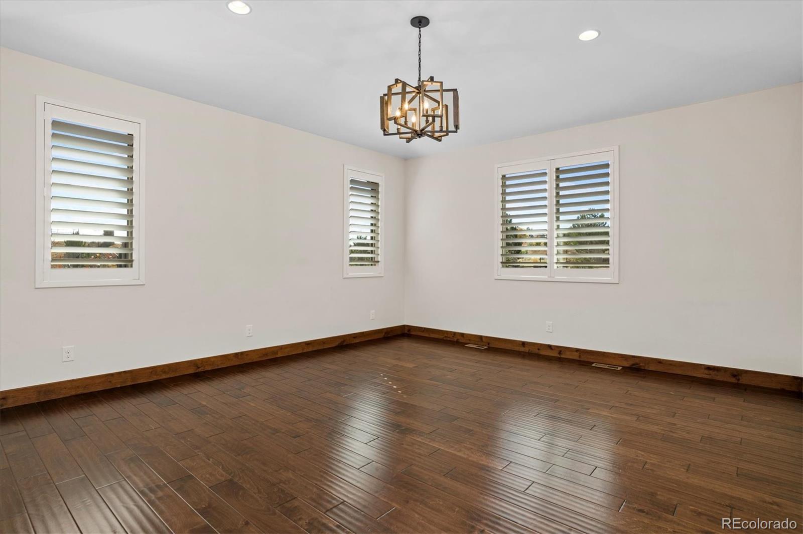 5561 Rim View Place Parker, CO 80134 - Photo 18 of 40 a view of an empty room with window and wooden floor