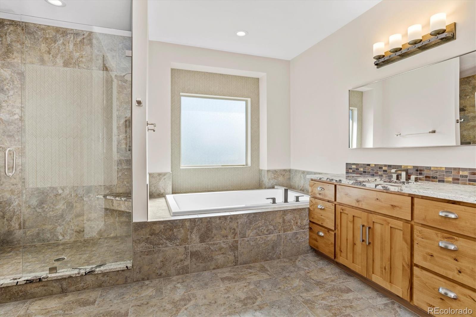 5561 Rim View Place Parker, CO 80134 - Photo 19 of 40 a bathroom with a tub sink and mirror