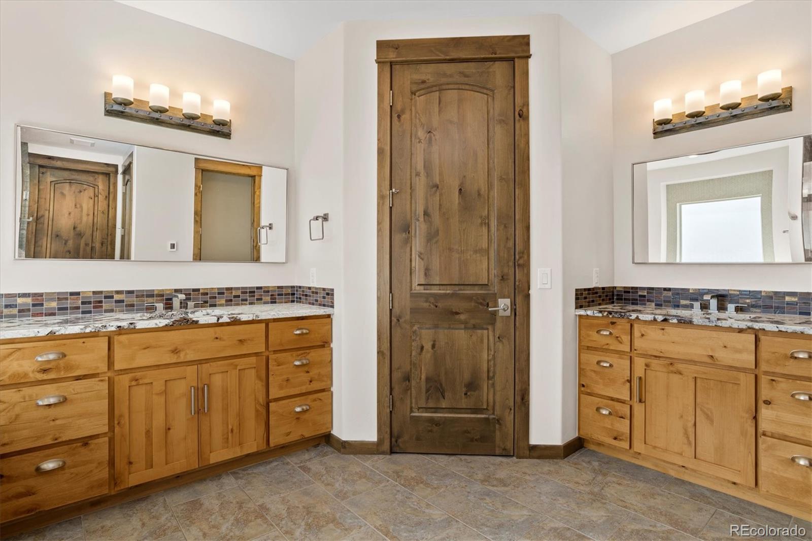 5561 Rim View Place Parker, CO 80134 - Photo 20 of 40 a bathroom with a granite countertop sink mirror and a