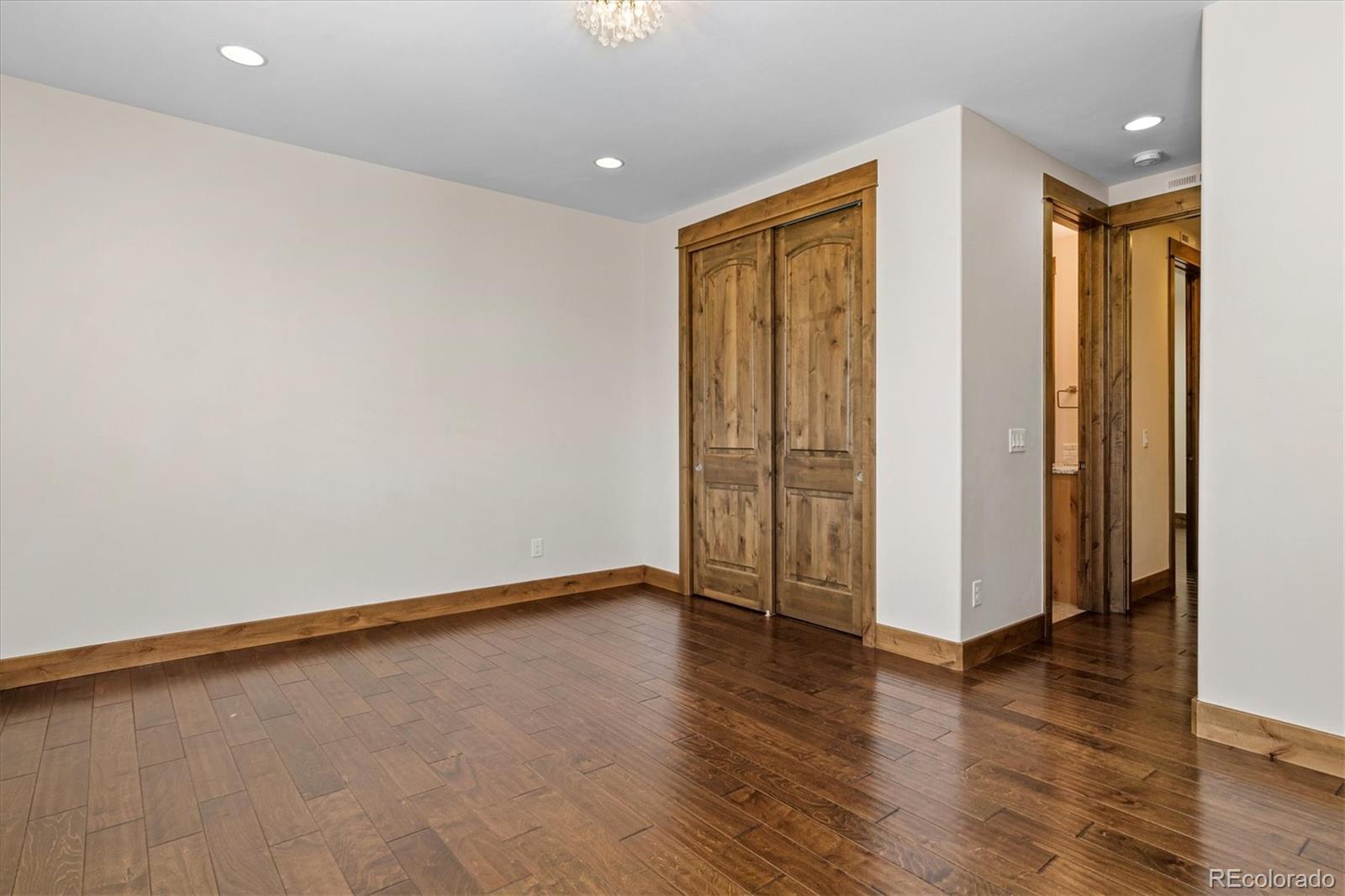 5561 Rim View Place Parker, CO 80134 - Photo 22 of 40 a view of an empty room with wooden floor and a window