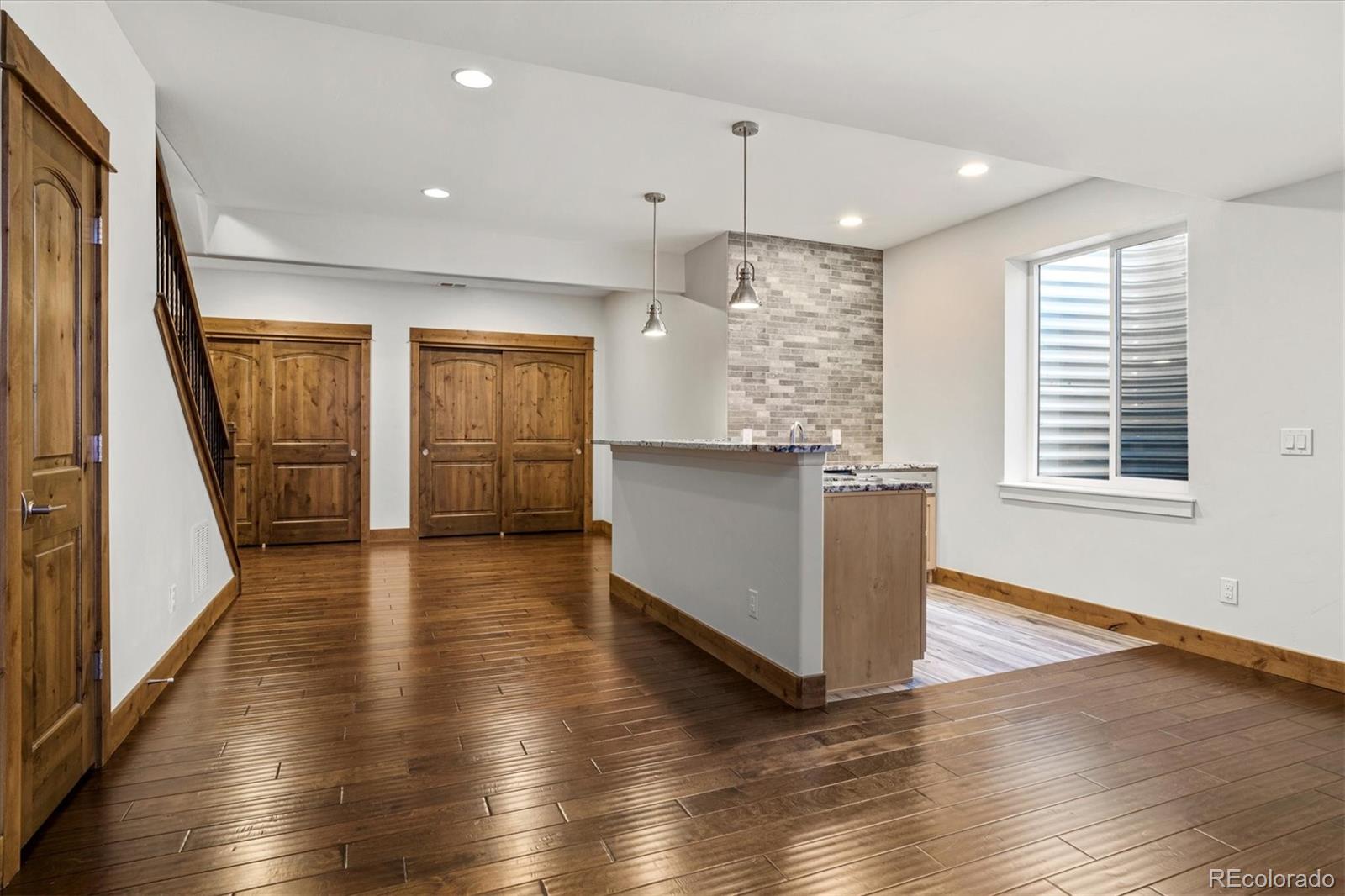 5561 Rim View Place Parker, CO 80134 - Photo 25 of 40 wooden floor in an empty room with a kitchen