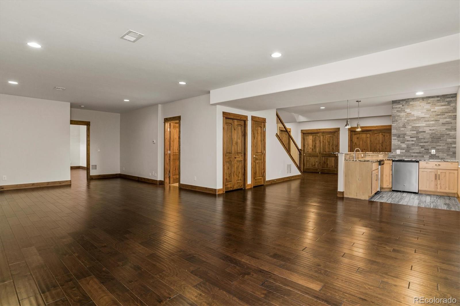 5561 Rim View Place Parker, CO 80134 - Photo 28 of 40 a view of an empty room with wooden floor and windows