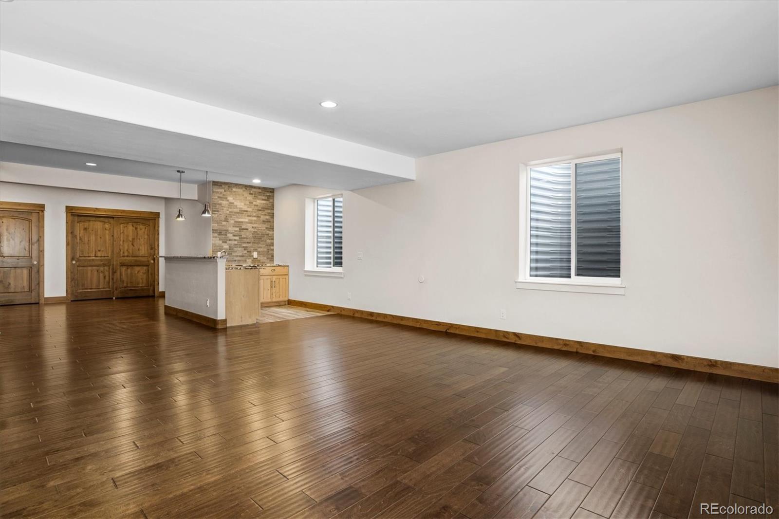 5561 Rim View Place Parker, CO 80134 - Photo 29 of 40 an empty room with wooden floor and windows