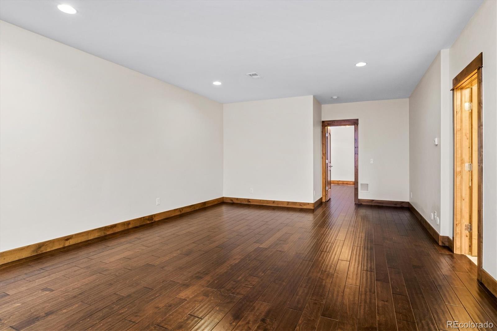 5561 Rim View Place Parker, CO 80134 - Photo 30 of 40 a view of an empty room with wooden floor and a window