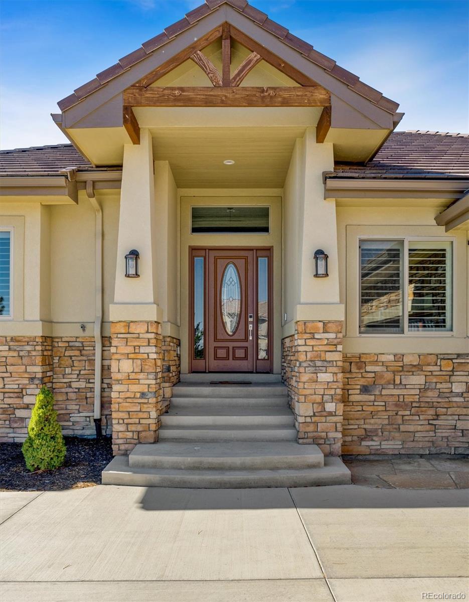 5561 Rim View Place Parker, CO 80134 - Photo 3 of 40 a front view of a house with a garden