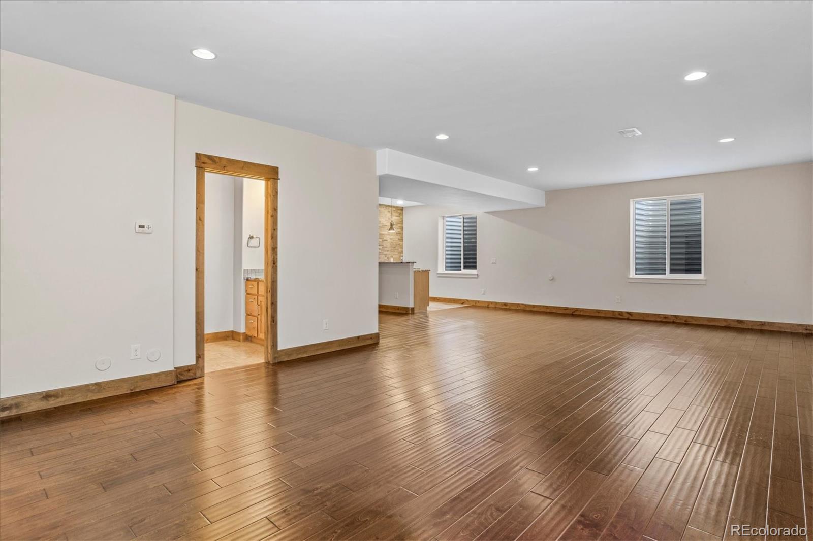 5561 Rim View Place Parker, CO 80134 - Photo 31 of 40 a view of an empty room with wooden floor and a window