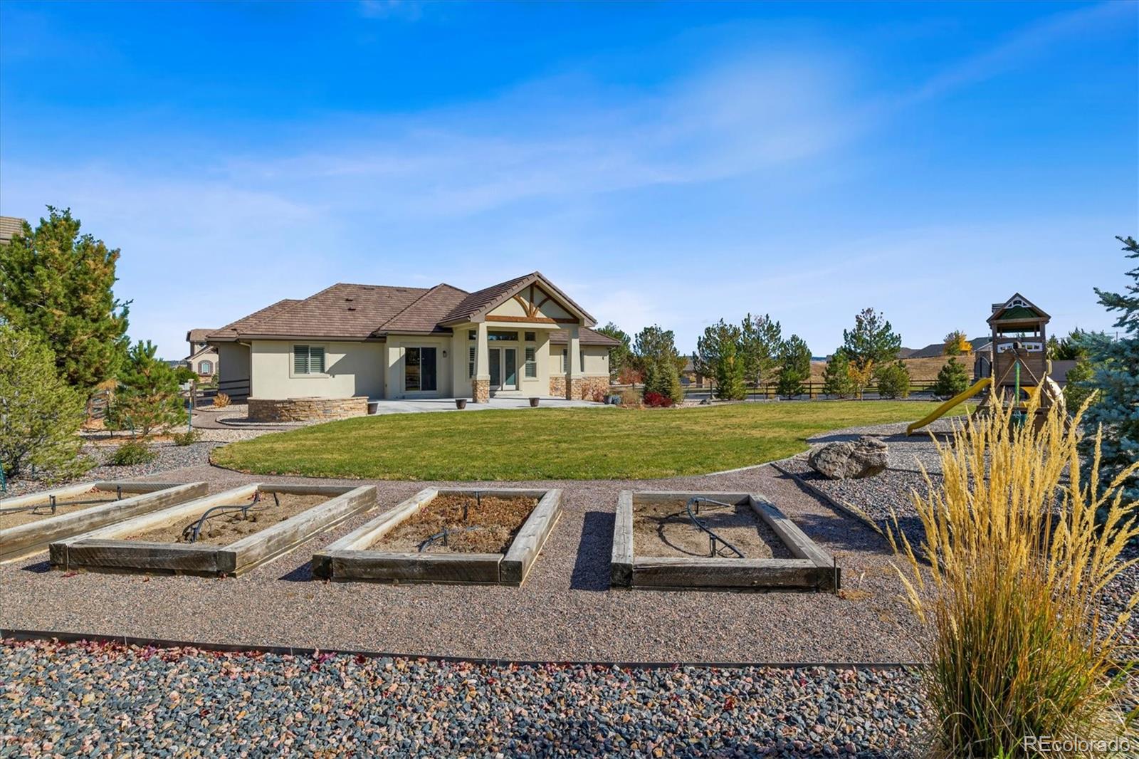 5561 Rim View Place Parker, CO 80134 - Photo 37 of 40 a view of a white house with a yard