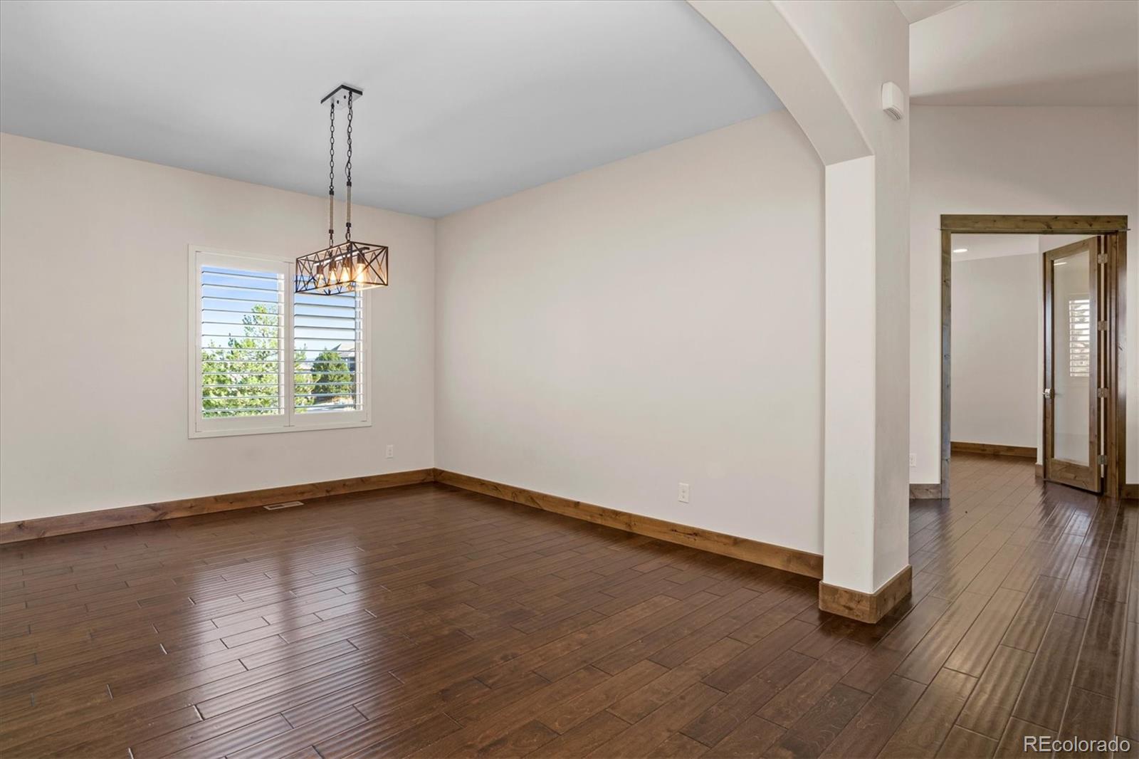 5561 Rim View Place Parker, CO 80134 - Photo 6 of 40 a view of empty room with wooden floor fan and window