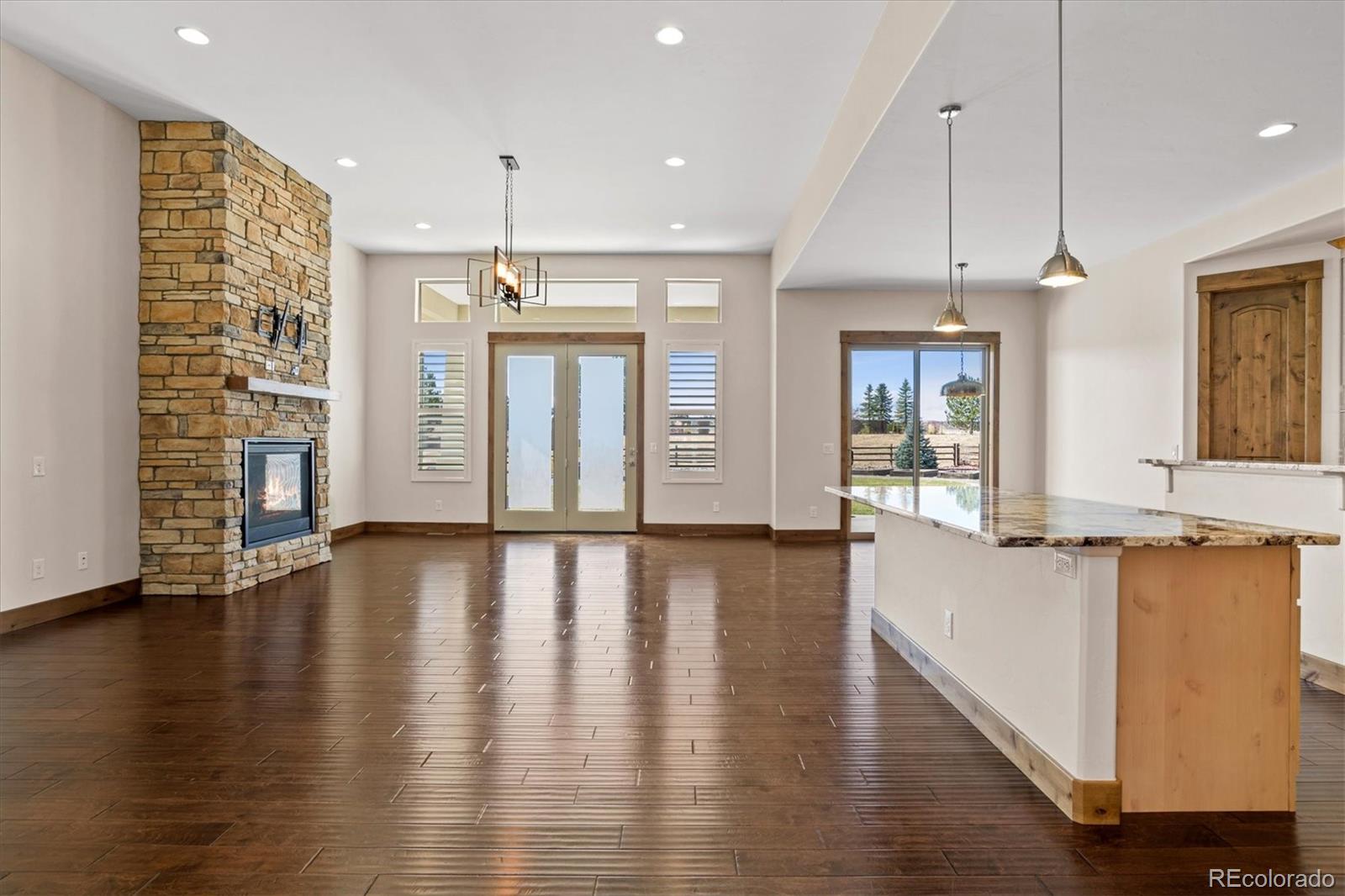 5561 Rim View Place Parker, CO 80134 - Photo 7 of 40 an empty room with wooden floor and outdoor view