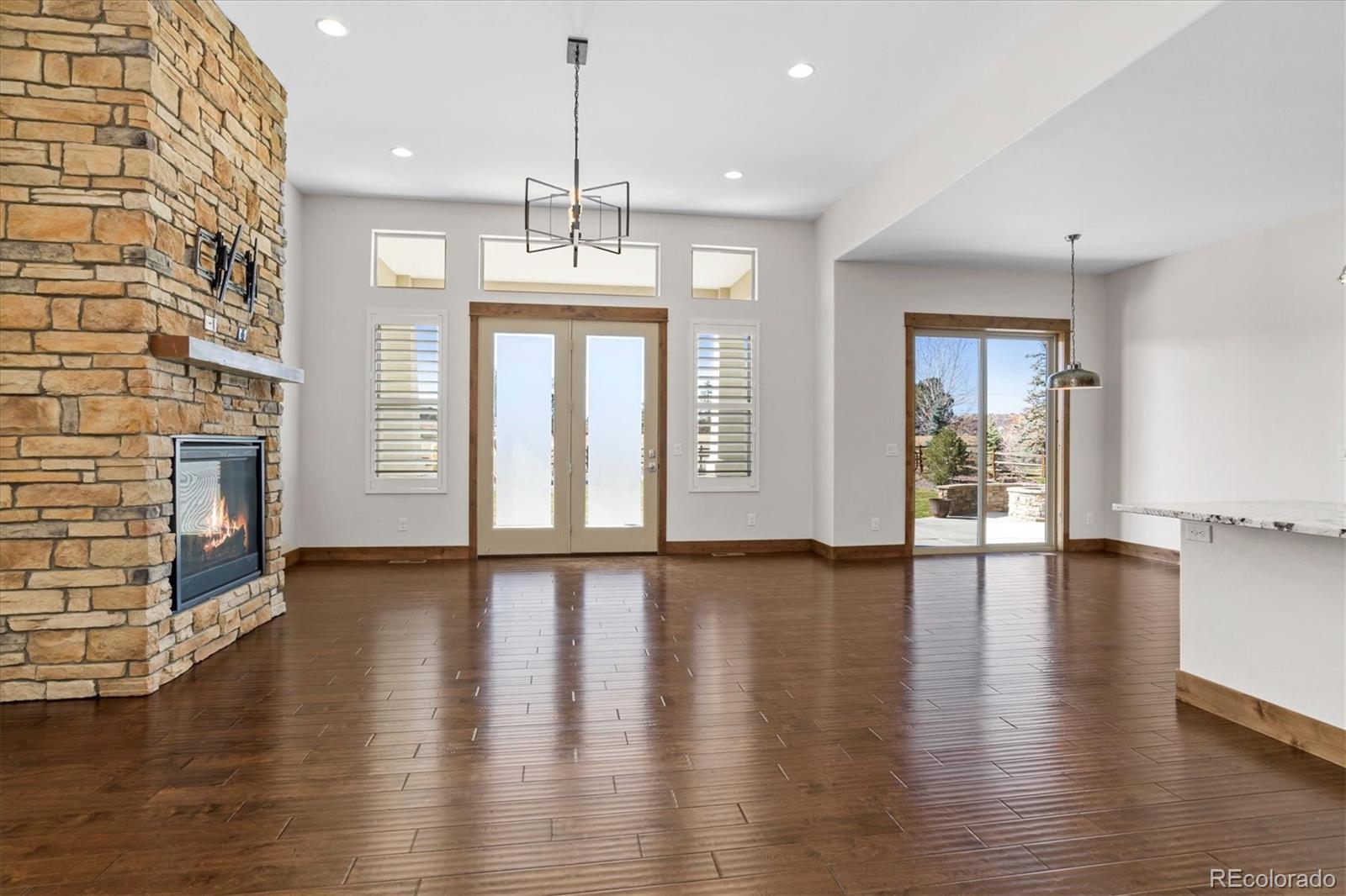 5561 Rim View Place Parker, CO 80134 - Photo 8 of 40 an empty room with wooden floor and windows