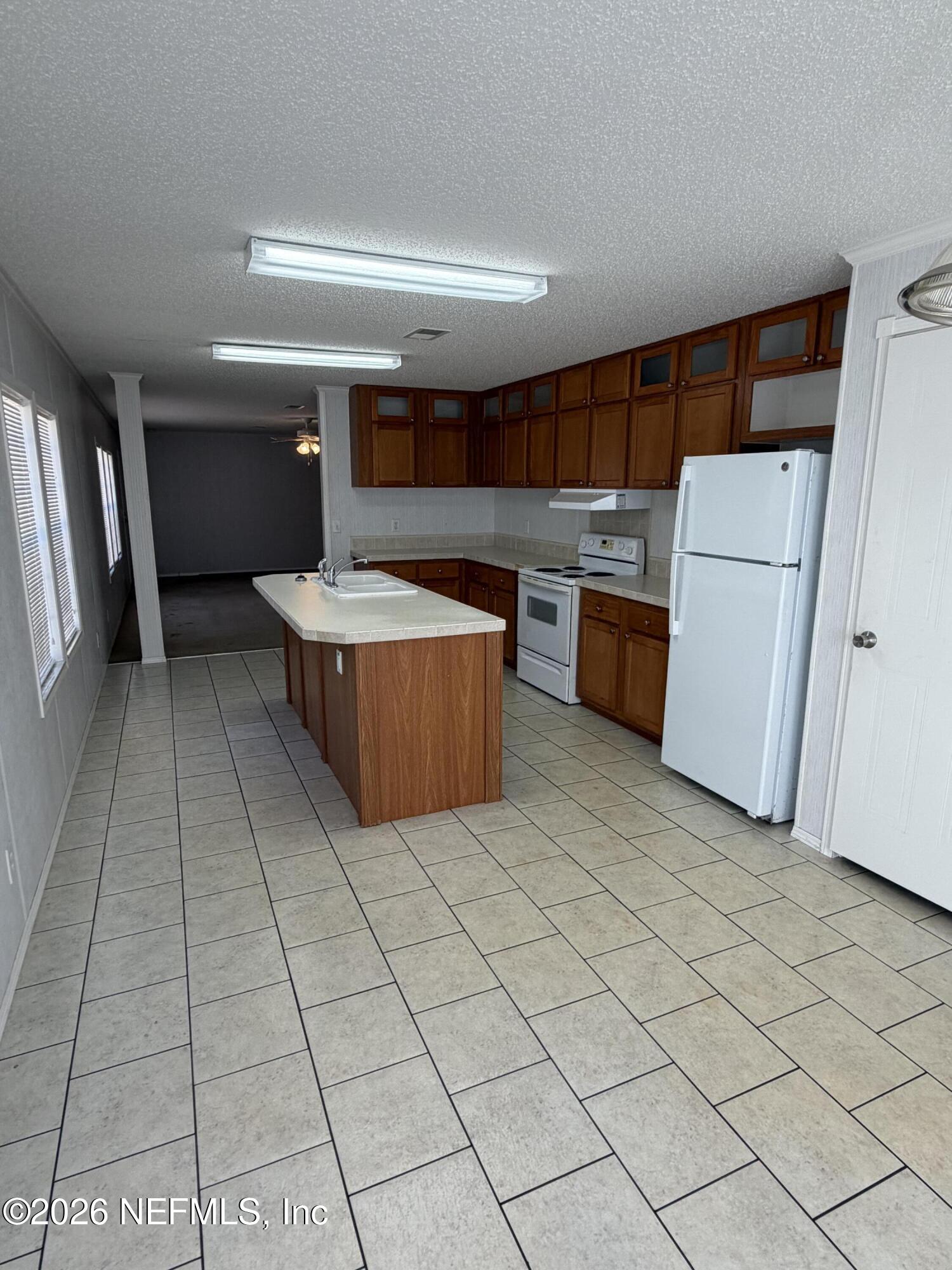 5597 Acadia Street Keystone Heights, FL 32656 - Photo 7 of 14 a living room with stainless steel appliances furniture a rug and a view of kitchen