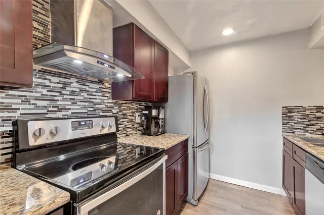 a kitchen with stainless steel appliances granite countertop a stove and a refrigerator