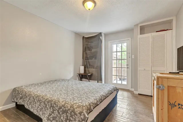 a bedroom with a bed and a flat tv screen on dresser