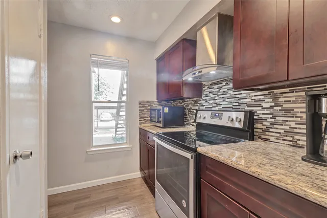 a kitchen with granite countertop cabinets stainless steel appliances and a window