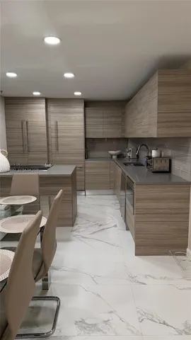 a kitchen with stainless steel appliances kitchen island granite countertop a stove and a sink