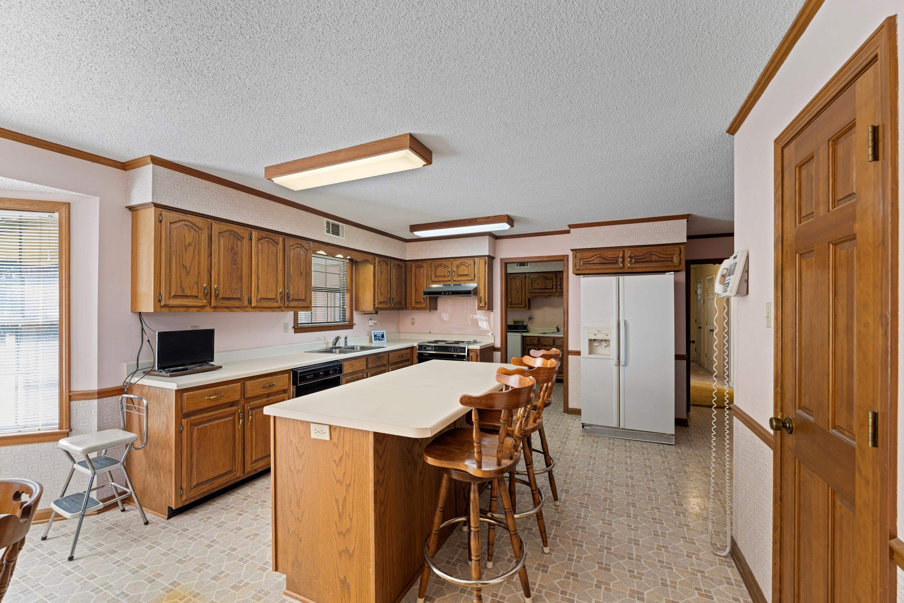 650 Blain Road Rossville, TN 38066 - Photo 11 of 32 Galley-style kitchen featuring abundant cabinetry, a center island with seating, breakfast area, and windows overlooking the scenic property.