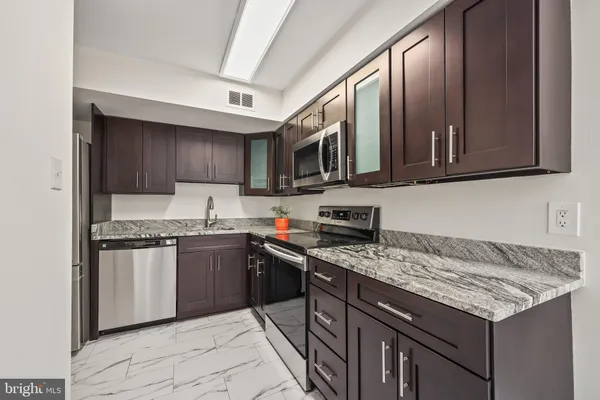 a kitchen with stainless steel appliances granite countertop a stove sink microwave and cabinets