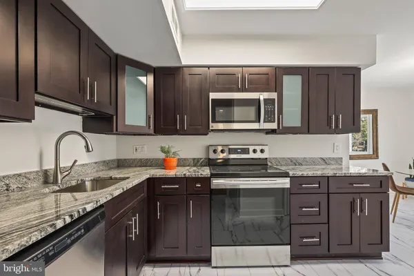 a kitchen with stainless steel appliances granite countertop a sink stove and microwave