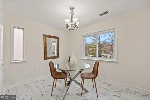 a dining room with chandelier and wooden floor