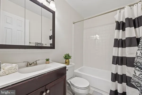 a bathroom with a granite countertop sink a toilet and bathtub