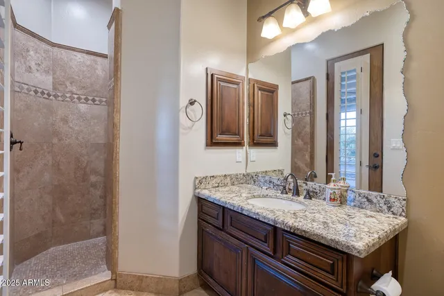 a bathroom with a granite countertop sink and a mirror