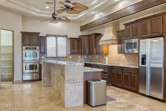 a kitchen with granite countertop a refrigerator a stove a sink and a refrigerator