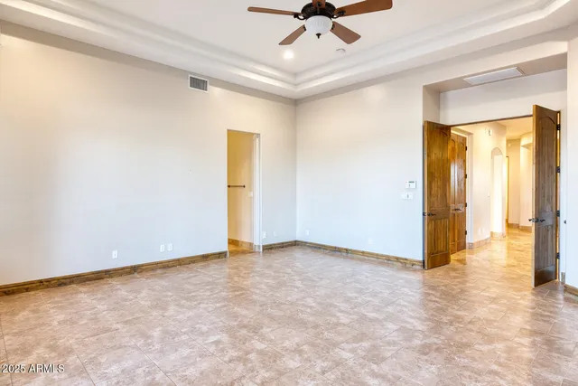 an empty room with a ceiling fan and carpet