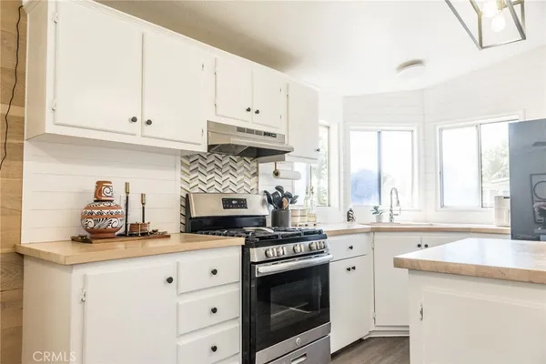 a kitchen with granite countertop white cabinets and appliances