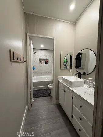 a bathroom with a granite countertop sink a mirror and a bathtub