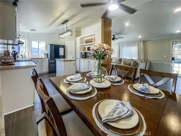 a dining room with furniture a kitchen view and wooden floor