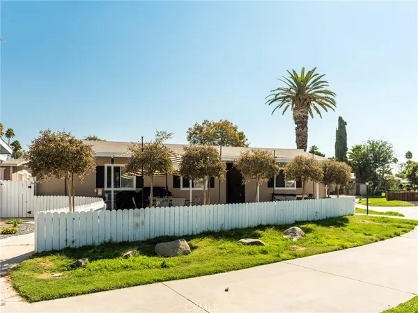 a front view of a house with a garden and tree