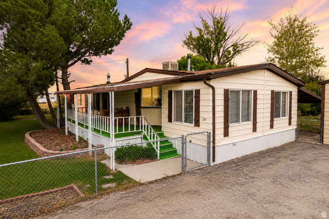 305 West Elmo Road Elmo, UT 84521 - Photo 1 of 27 Cream-colored siding with brown trim and shutters