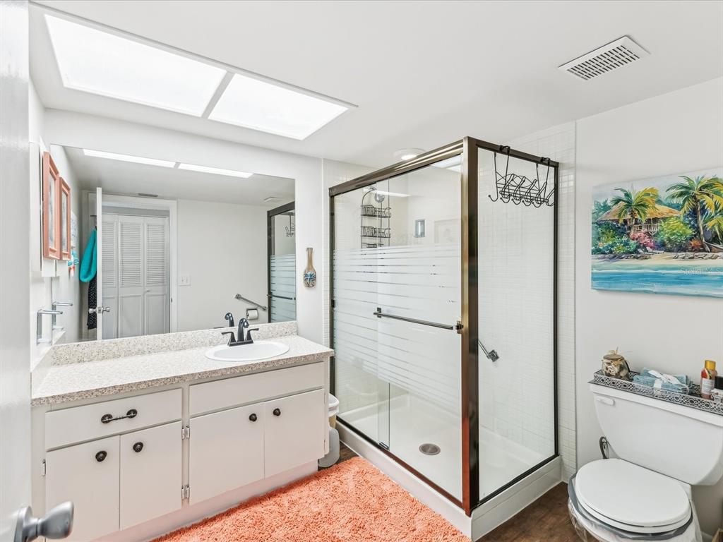 10216 Regal Drive, Unit 409 Largo, FL 33774 - Photo 15 of 42 a bathroom with a sink a toilet and shower