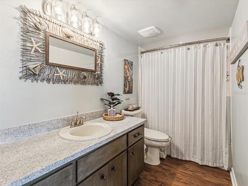 10216 Regal Drive, Unit 409 Largo, FL 33774 - Photo 19 of 42 a bathroom with a granite countertop sink vanity mirror and toilet