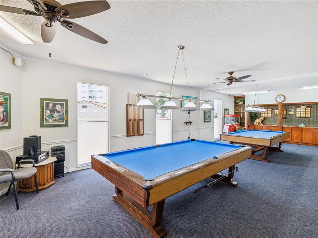 10216 Regal Drive, Unit 409 Largo, FL 33774 - Photo 35 of 42 a room with pool table and a chandelier