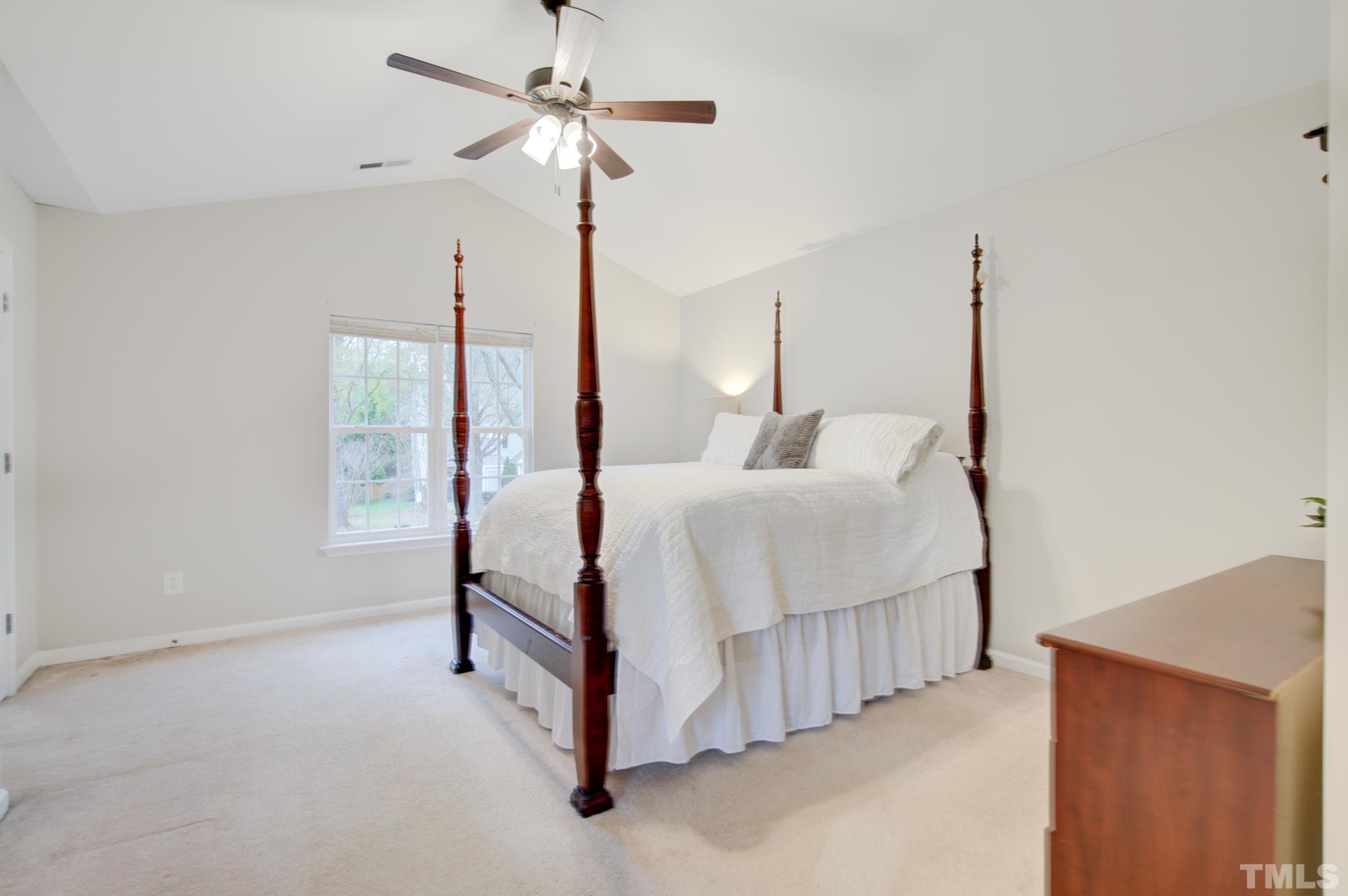 8206 Shadow Stone Court Raleigh, NC 27613 - Photo 28 of 52 a spacious bedroom with a bed a chandelier and a chandelier