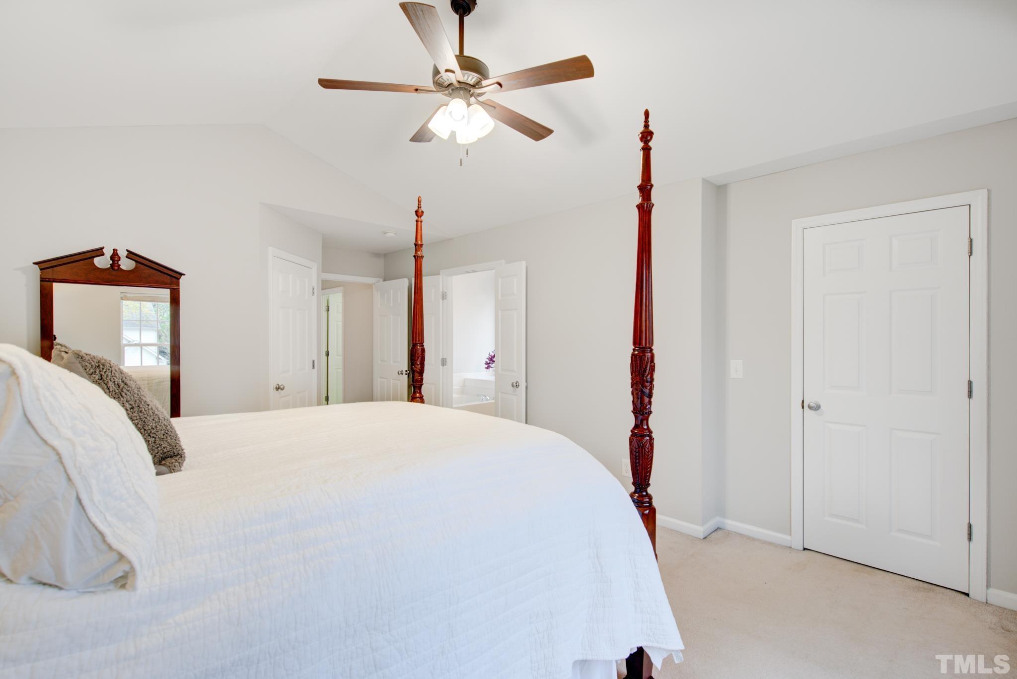 8206 Shadow Stone Court Raleigh, NC 27613 - Photo 30 of 52 a bedroom with a bed and a chandelier