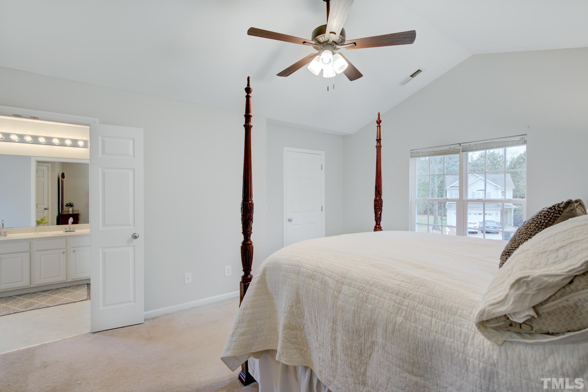 8206 Shadow Stone Court Raleigh, NC 27613 - Photo 31 of 52 a bedroom with a large bed and a chandelier