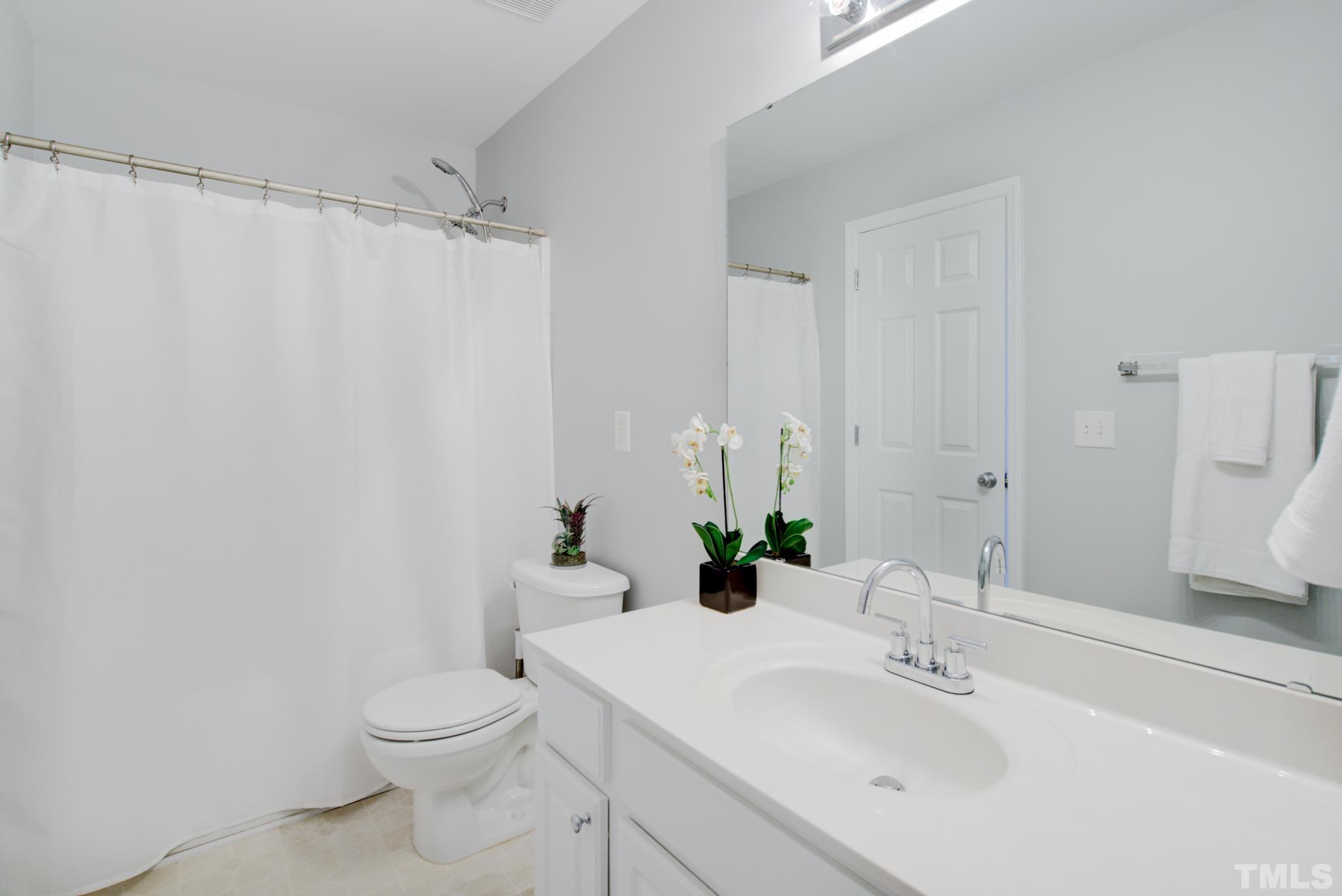 8206 Shadow Stone Court Raleigh, NC 27613 - Photo 36 of 52 a bathroom with a sink a toilet and shower curtain