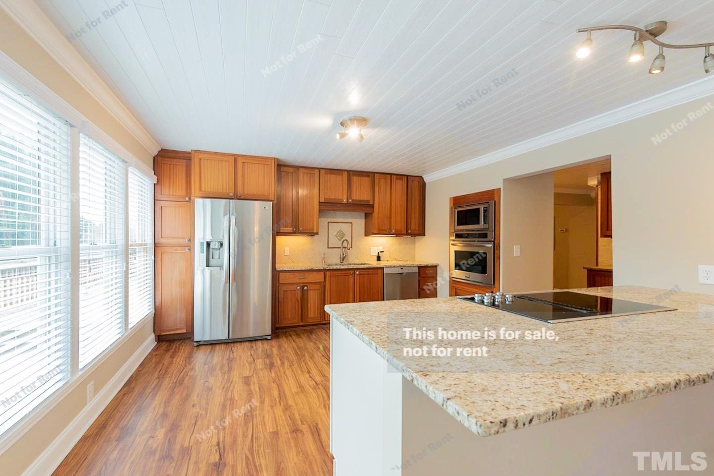 12008 Shooting Club Road Raleigh, NC 27613 - Photo 2 of 23 a view of kitchen with refrigerator stove and wooden floor