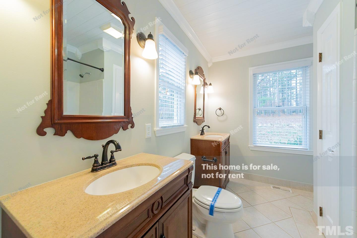 12008 Shooting Club Road Raleigh, NC 27613 - Photo 16 of 23 a bathroom with a sink and a mirror